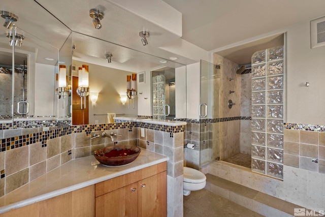 280 Island Ave Apt 802, Reno, NV 89501 - bathroom featuring a shower stall, toilet, tile patterned floors, tile walls, and decorative backsplash