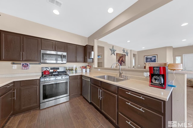 5310 Village Meadows Dr, Sparks, NV 89436 - kitchen featuring appliances with stainless steel finishes, a peninsula, a sink, light countertops, and dark brown cabinetry