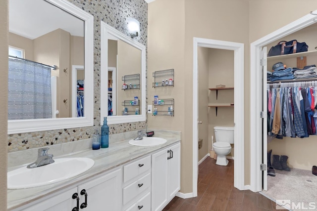 5310 Village Meadows Dr, Sparks, NV 89436 - bathroom with double vanity, toilet, wood finished floors, a spacious closet, and baseboards