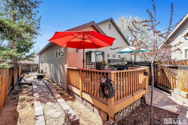 5310 Village Meadows Dr, Sparks, NV 89436 - rear view of house with a deck, stucco siding, a fenced backyard, and outdoor dining space