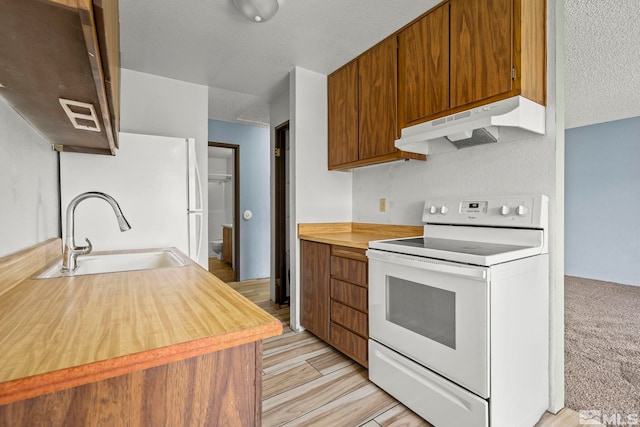 4604 Neil Rd Unit 122, Reno, NV 89502 - kitchen featuring white appliances, under cabinet range hood, a sink, light countertops, and a textured ceiling
