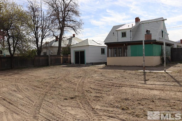 136 W First St, Winnemucca, NV 89445 - back of property with a chimney, fence, and a sunroom