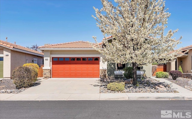 2140 Avella Dr, Sparks, NV 89434 - view of front of home featuring an attached garage, a tiled roof, concrete driveway, stucco siding, and stone siding