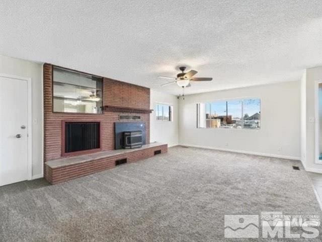 427 D St, Hawthorne, NV 89415 - unfurnished living room with a fireplace, carpet floors, a ceiling fan, a textured ceiling, and baseboards