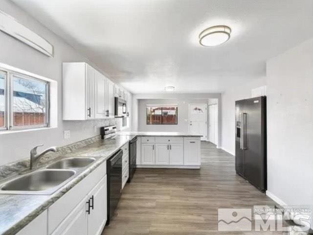 427 D St, Hawthorne, NV 89415 - kitchen with appliances with stainless steel finishes, a sink, a peninsula, white cabinets, and wood finished floors