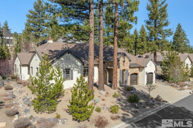 20605 Parc Foret Dr, Reno, NV 89511 - english style home with driveway, stucco siding, an attached garage, and stone siding