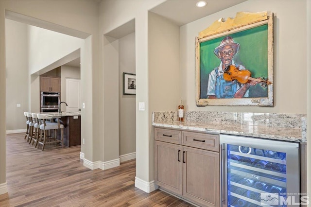 20605 Parc Foret Dr, Reno, NV 89511 - bar area with wine cooler, baseboards, wood finished floors, stainless steel double oven, and recessed lighting