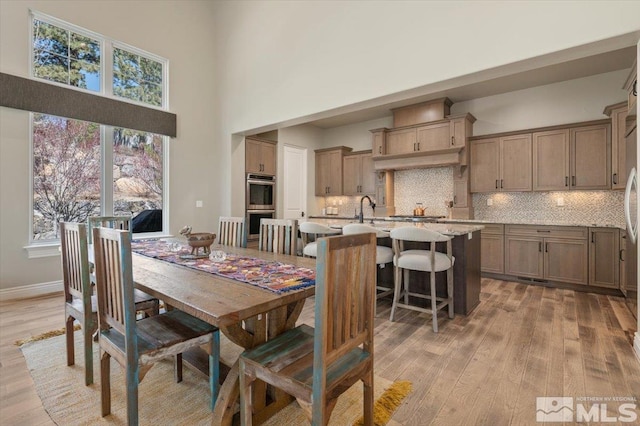 20605 Parc Foret Dr, Reno, NV 89511 - dining room featuring a towering ceiling, light wood-style floors, and baseboards
