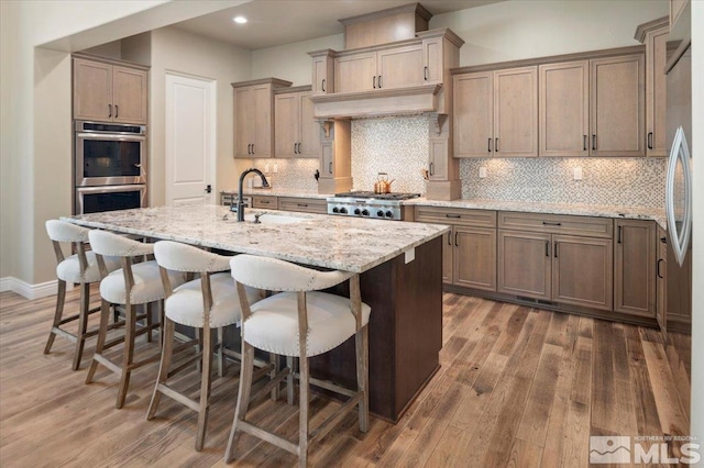 20605 Parc Foret Dr, Reno, NV 89511 - kitchen featuring stainless steel appliances, wood finished floors, light stone counters, and recessed lighting