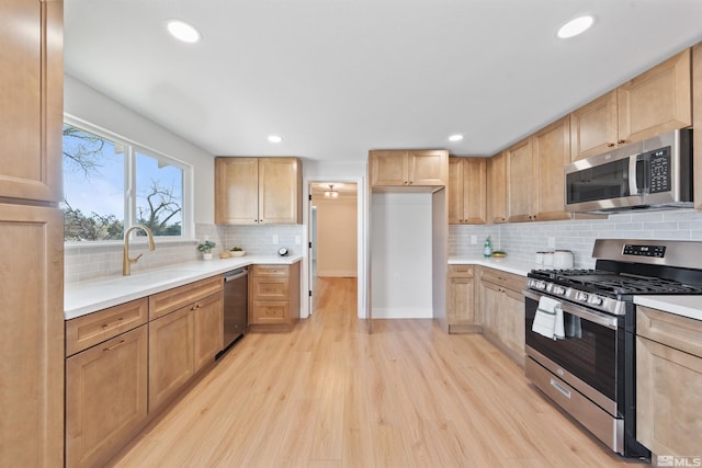 1309 Raeline Ln, Minden, NV 89423 - kitchen with appliances with stainless steel finishes, light wood-style flooring, backsplash, light brown cabinetry, and recessed lighting