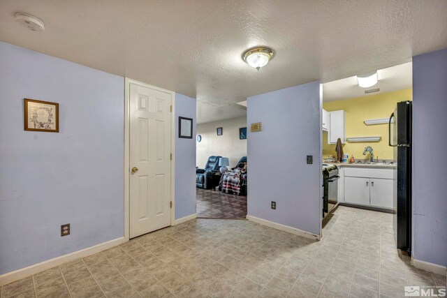 2555 Clear Acre Ln Unit 73, Reno, NV 89512 - empty room featuring a smoke detector, baseboards, a sink, and a textured ceiling