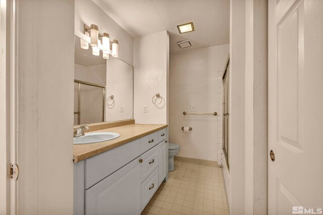 2555 Clear Acre Ln Unit 73, Reno, NV 89512 - full bathroom featuring a shower with shower door, toilet, vanity, tile patterned floors, and baseboards