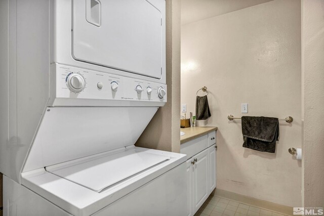 2555 Clear Acre Ln Unit 73, Reno, NV 89512 - washroom featuring stacked washer / drying machine, cabinet space, and baseboards