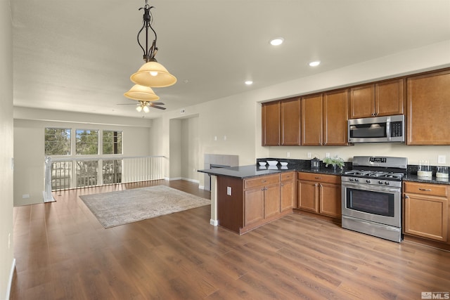 2490 Eastshore Pl, Reno, NV 89509 - kitchen with stainless steel appliances, dark countertops, a peninsula, recessed lighting, and brown cabinetry