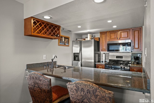 759 Boulder Ct Unit M, Stateline, NV 89449 - kitchen with appliances with stainless steel finishes, a sink, brown cabinets, dark stone countertops, and recessed lighting
