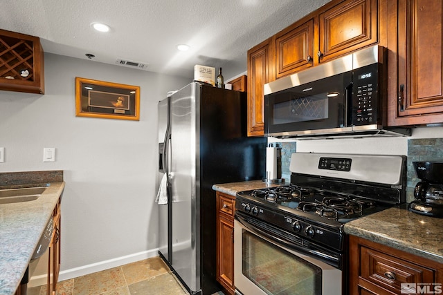 759 Boulder Ct Unit M, Stateline, NV 89449 - kitchen with appliances with stainless steel finishes, baseboards, brown cabinets, recessed lighting, and a textured ceiling