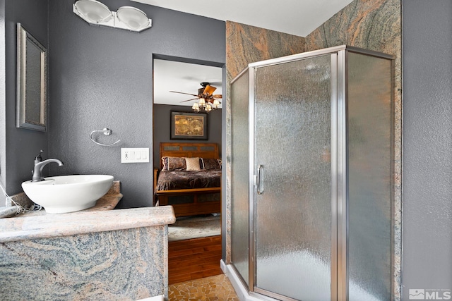 759 Boulder Ct Unit M, Stateline, NV 89449 - bathroom featuring a sink, connected bathroom, a textured wall, a shower stall, and wood finished floors