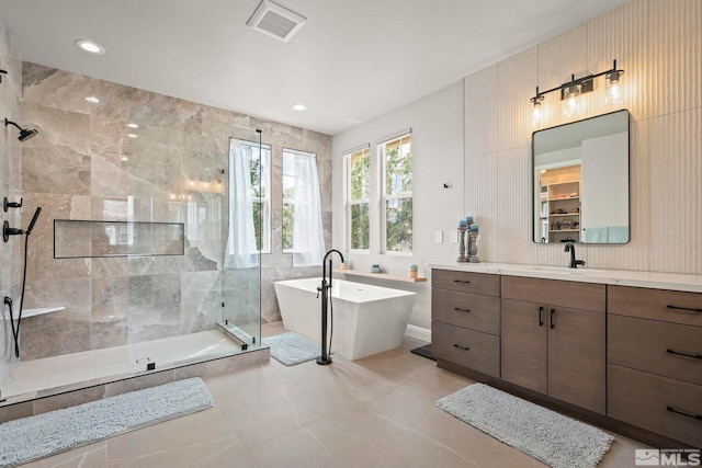 full bath featuring a shower stall, a freestanding tub, vanity, and recessed lighting