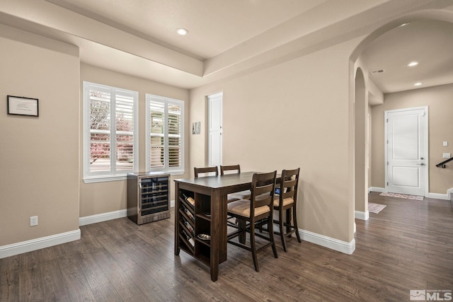 dining room with arched walkways, wood finished floors, baseboards, recessed lighting, and heating unit