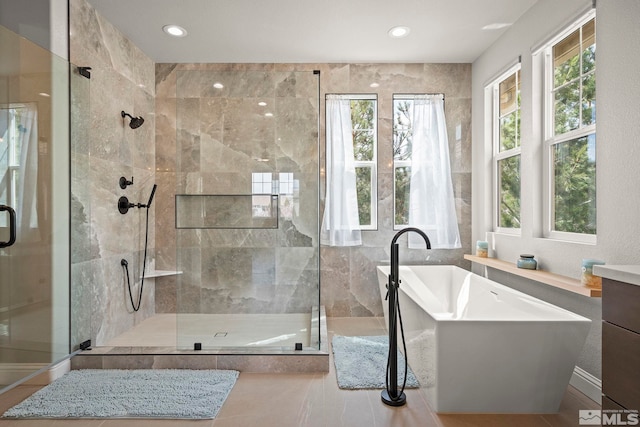 full bathroom with plenty of natural light, a shower stall, a soaking tub, recessed lighting, and tile walls
