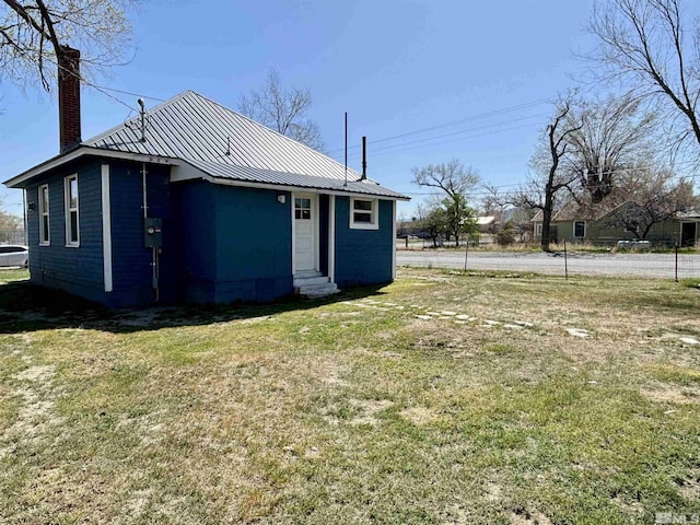 295 Apache St, Imlay, NV 89418 - rear view of property featuring entry steps, a chimney, a yard, and metal roof
