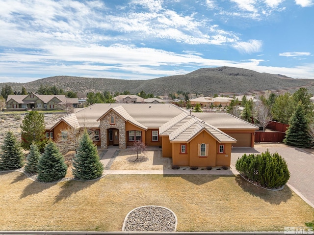 15355 Redmond Loop, Reno, NV 89511 - view of front of house featuring a mountain view, a tile roof, stucco siding, a garage, and driveway