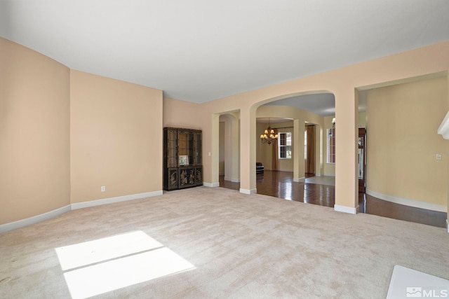 15355 Redmond Loop, Reno, NV 89511 - empty room featuring arched walkways, carpet flooring, a chandelier, and baseboards