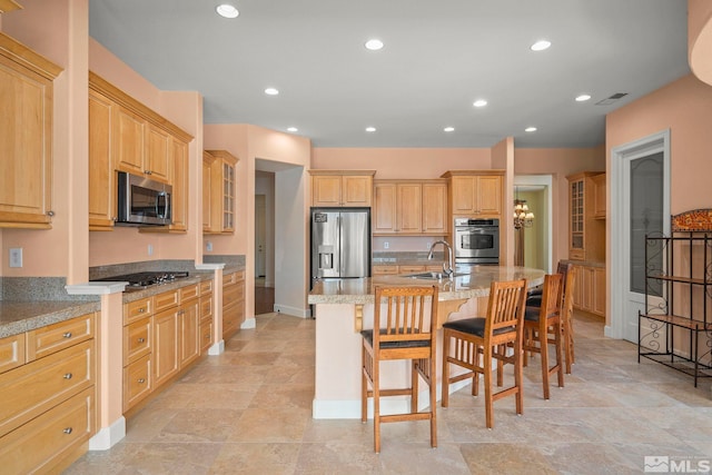 15355 Redmond Loop, Reno, NV 89511 - kitchen with appliances with stainless steel finishes, a kitchen breakfast bar, light brown cabinets, a sink, and an island with sink