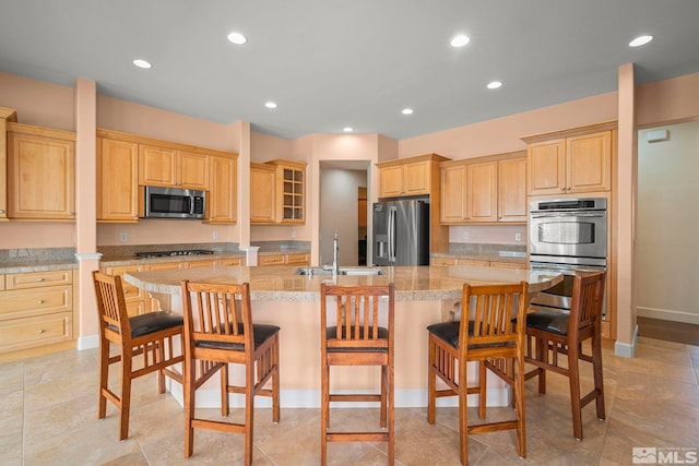 15355 Redmond Loop, Reno, NV 89511 - kitchen with appliances with stainless steel finishes, a sink, light brown cabinetry, a spacious island, and a kitchen bar