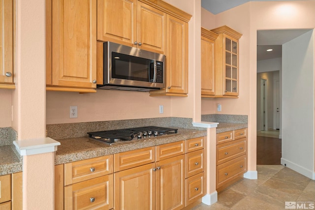 15355 Redmond Loop, Reno, NV 89511 - kitchen with stainless steel appliances, glass insert cabinets, light countertops, baseboards, and light tile patterned floors