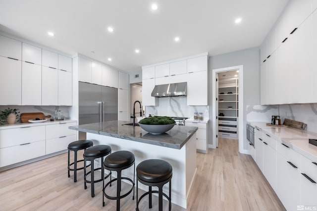 47 Campolina St Unit 23-1, Reno, NV 89511 - kitchen featuring modern cabinets, wall chimney range hood, a breakfast bar area, light wood-type flooring, and recessed lighting