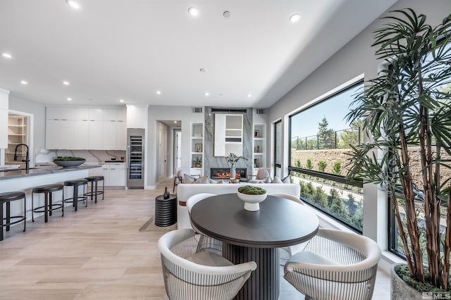 47 Campolina St Unit 23-1, Reno, NV 89511 - dining room featuring beverage cooler, recessed lighting, a premium fireplace, and light wood-style flooring