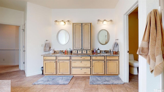 full bathroom featuring double vanity, tile patterned floors, and toilet