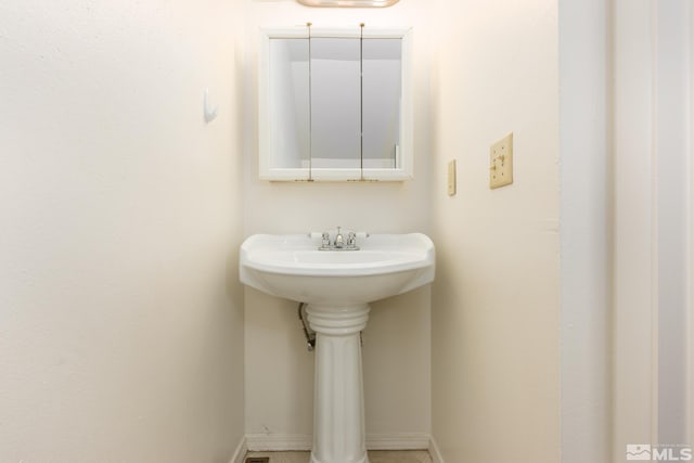 bathroom featuring baseboards and a sink