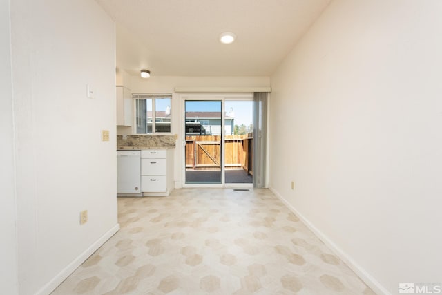 unfurnished room with baseboards and light flooring