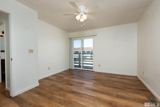 empty room with hardwood / wood-style floors, a ceiling fan, a textured ceiling, and baseboards