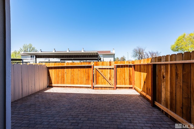 view of patio featuring fence and a gate