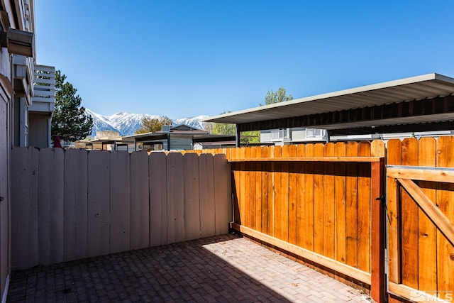 view of patio / terrace featuring a mountain view, a gate, and fence