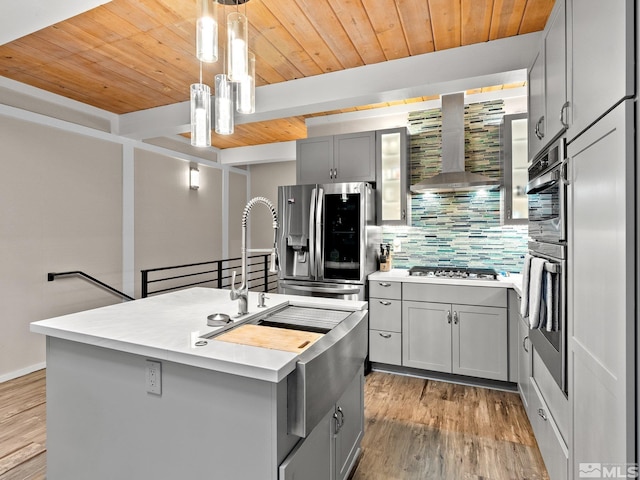 989 Tahoe Blvd Unit 91, Incline Village, NV 89451 - kitchen featuring gray cabinetry, wall chimney range hood, appliances with stainless steel finishes, wooden ceiling, and tasteful backsplash