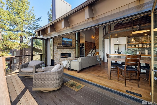 wooden terrace featuring an outdoor living space with a fireplace