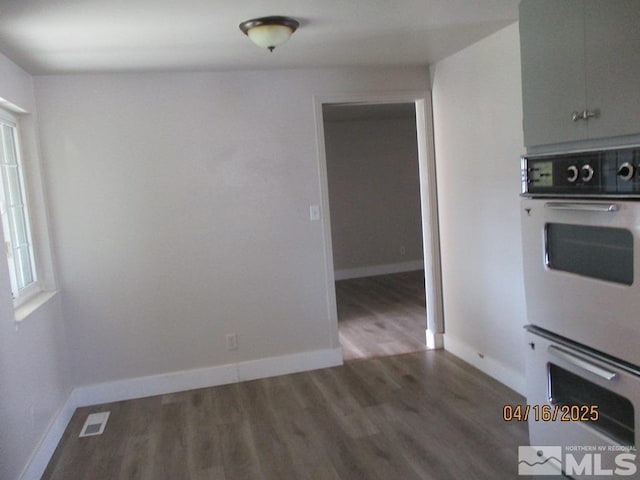 unfurnished dining area featuring wood finished floors and baseboards