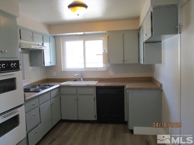 kitchen with dishwasher, a sink, electric stovetop, double oven, and under cabinet range hood