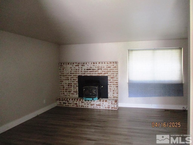 unfurnished living room with wood finished floors and baseboards