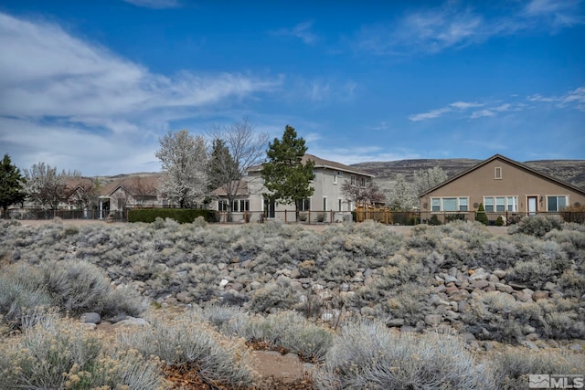 6647 Fabric Dr, Sparks, NV 89436 - back of house featuring fence, a mountain view, and stucco siding