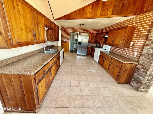 988 Gummow Dr, Fallon, NV 89406 - kitchen with white appliances, a sink, brown cabinets, high vaulted ceiling, and light tile patterned floors