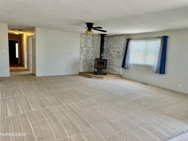 988 Gummow Dr, Fallon, NV 89406 - unfurnished living room with a wood stove, carpet floors, and ceiling fan