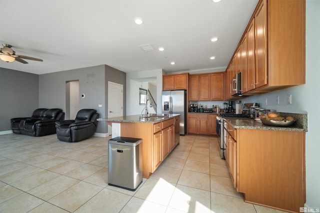 2575 Piero Ct, Sparks, NV 89434 - kitchen with stainless steel appliances, a sink, dark stone countertops, light tile patterned floors, and open floor plan