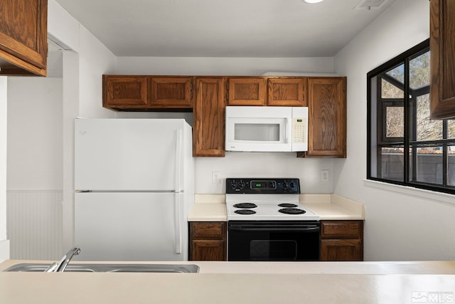 2193 Kietzke Ln Unit C, Reno, NV 89502 - kitchen with white appliances, a sink, light countertops, and brown cabinets