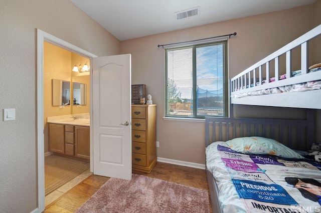 166 Oakridge Dr, Dayton, NV 89403 - bedroom with baseboards, light wood-type flooring, connected bathroom, and a sink