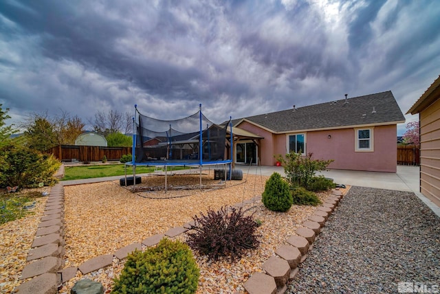 166 Oakridge Dr, Dayton, NV 89403 - back of house with a trampoline, a patio area, stucco siding, and roof with shingles